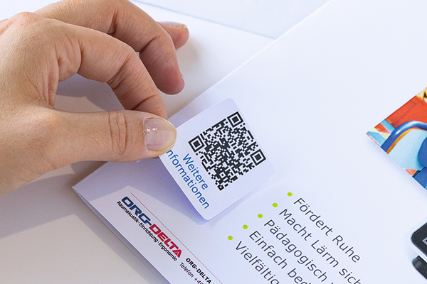 Quadratisches QR-Code-Etikett, das auf ein Dokument geklebt wird.