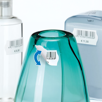 Ein türkisfarbener Glasbehälter mit einem Preisschild, umgeben von weiteren Flaschen und Behältern.