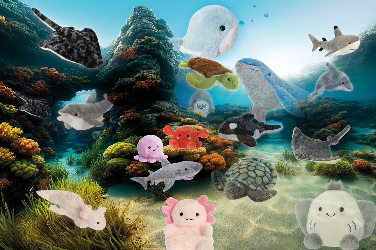Plüschtiere von verschiedenen Meeresbewohnern, darunter Wale, Haie, Schildkröten und Seesterne, in einer lebhaften Unterwasserlandschaft.