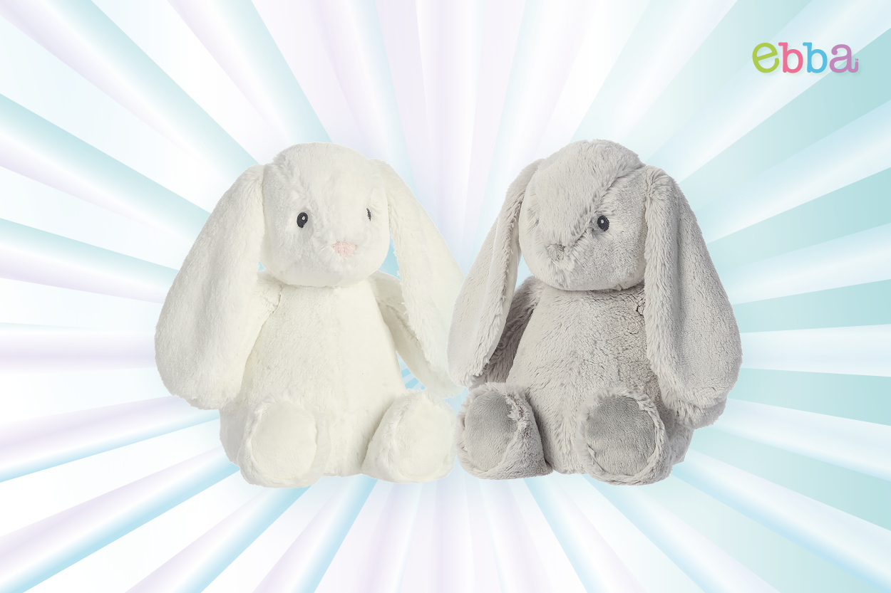 Zwei Plüschhasen in Weiß und Grau mit langen Ohren und runden Körpern, vor einem hellen, strahlenden Hintergrund." 

(Note: The text is already in German and does not require translation. It is clear and fluent as is.)