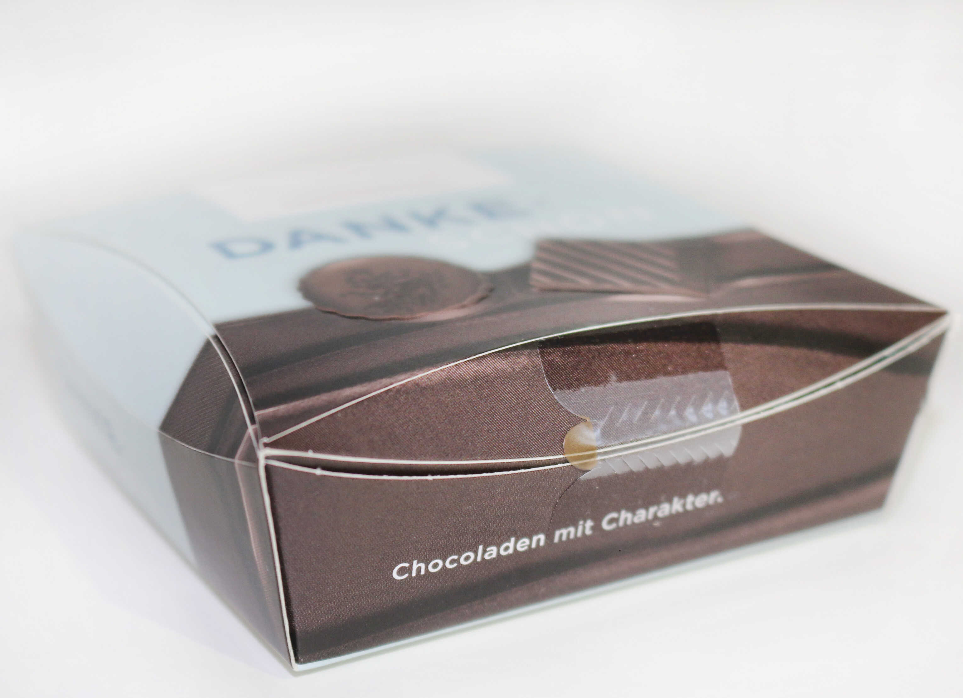 Schachtel mit Schokolade, beschriftet mit "Danke" und dem Text "Schokoladen mit Charakter."