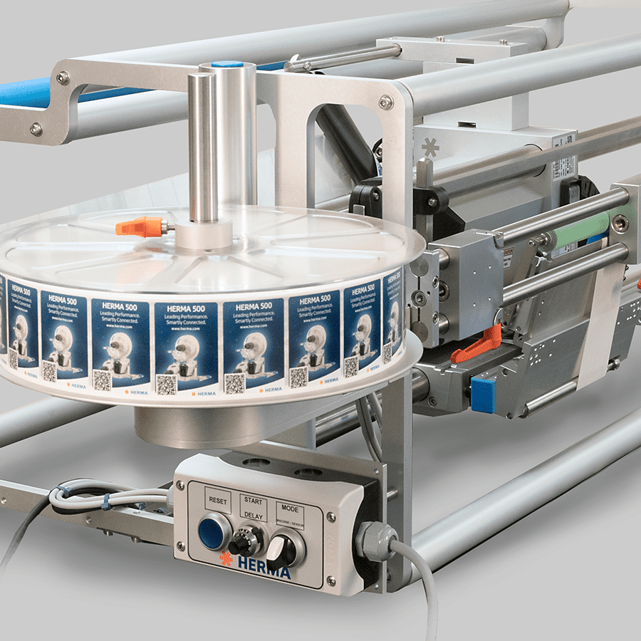 Eine Etikettiermaschine mit einer Rolle von Etiketten, die auf einem drehbaren Teller montiert ist, und einem Bedienfeld zur Steuerung.