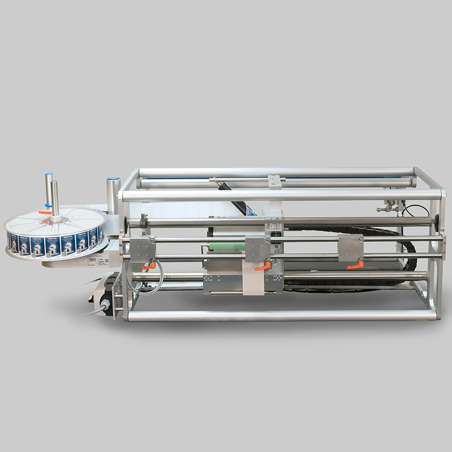 Maschine zur automatischen Etikettierung mit einem Förderband und einer Rollenhalterung für Etiketten.