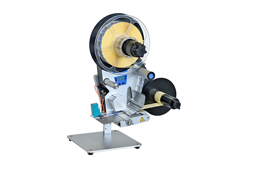 Ein Etikettiergerät mit zwei Rollen, einer Steuerungseinheit und einem stabilen Standfuß, geeignet für verschiedene Etikettenanwendungen.