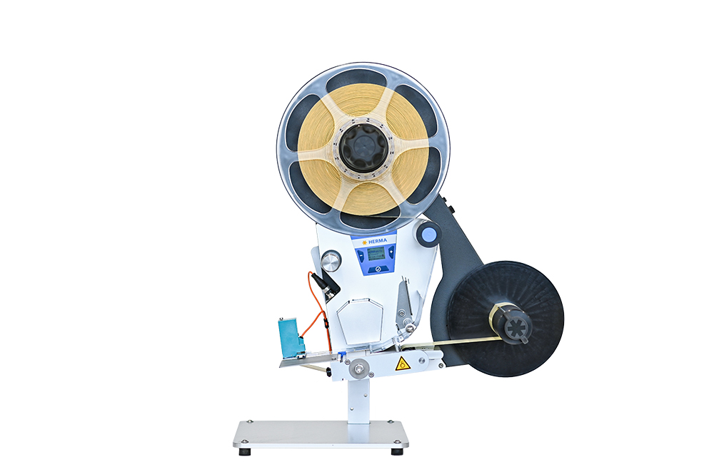 Eine Maschine zur Verarbeitung von Bändern, ausgestattet mit einer großen Spule und einem Bedienfeld zur Steuerung.