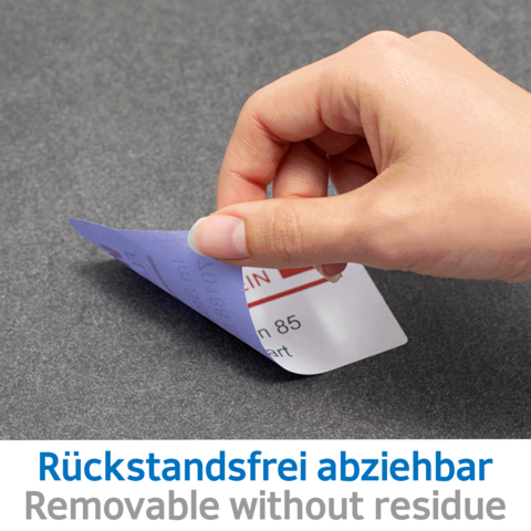 Eine Hand zieht einen abziehbaren Aufkleber von einer grauen Oberfläche. Der Aufkleber zeigt den Text "Rückstandsfrei abziehbar".