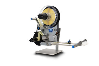 Ein Etikettiergerät mit einer großen Spule, einem Abroller und einer Steuerungseinheit zur Anbringung von Etiketten auf Produkten.