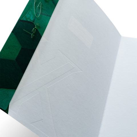 Grüner Umschlag mit geometrischem Muster, innen leer und unbeschriftet.