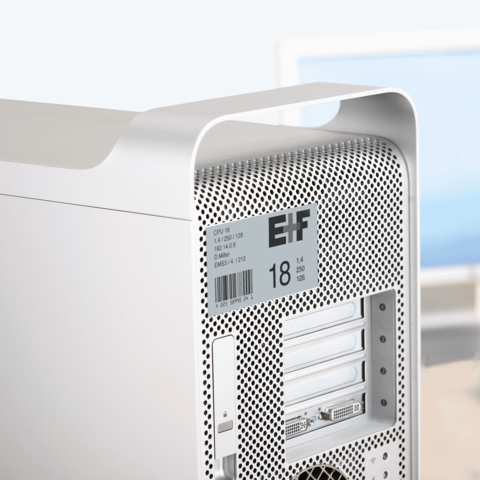 Silberner Computer-Tower mit Belüftungsgitter und technischen Spezifikationen auf einem Aufkleber.