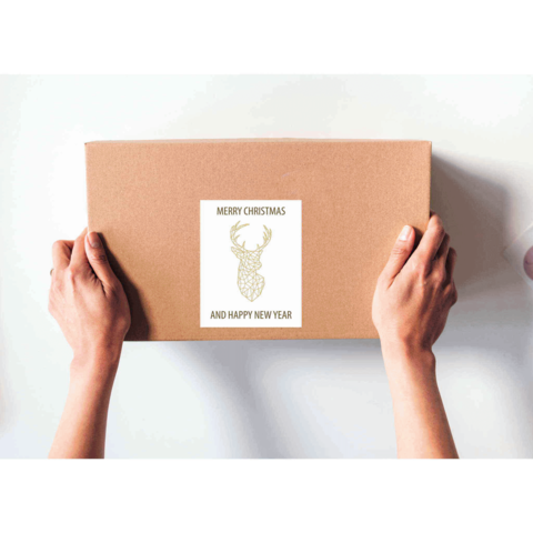 Geschenkbox mit einem Etikett, das "Frohe Weihnachten und ein glückliches neues Jahr" sowie ein Hirschmotiv zeigt.