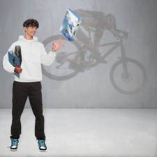 Ein junger Mann in einem weißen Hoodie steht mit zwei Boxen in der Hand, während im Hintergrund ein Radfahrer auf einem Mountainbike zu sehen ist.