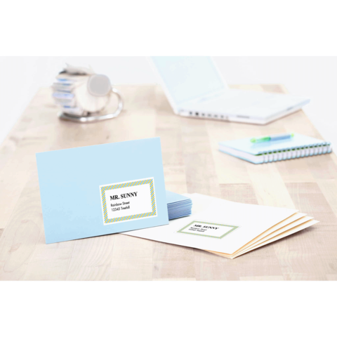 Blaue Karte mit dem Namen "Mr. Sunny" und der Aufschrift "Tischkarten". Daneben liegen weitere beige und weiße Karten auf einem Holztisch.