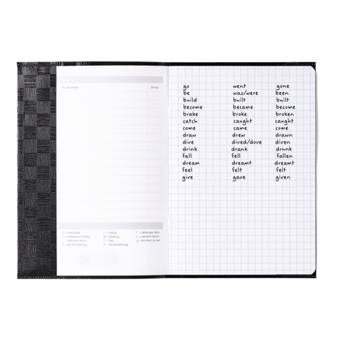 Ein offenes Notizbuch mit einer Liste unregelmäßiger Verben in englischer Sprache, einschließlich ihrer Grundform und Vergangenheitsformen.