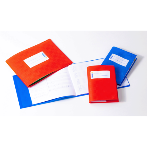 Bunte Ordner und ein Notizbuch liegen auf einem Tisch. Die Ordner sind rot und blau, mit beschriftbaren Etiketten auf der Vorderseite.