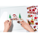 Hände platzieren Weihnachtsdekorationen auf einer glatten Oberfläche, darunter ein Weihnachtsmann, Tannenbäume und ein Herz.