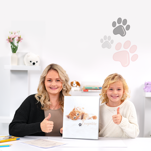 Eine Frau und ein Kind zeigen den Daumen nach oben, während sie ein Katzenbuch halten. Im Hintergrund sind Pfotenabdrücke und verschiedene Dekorationen zu sehen.