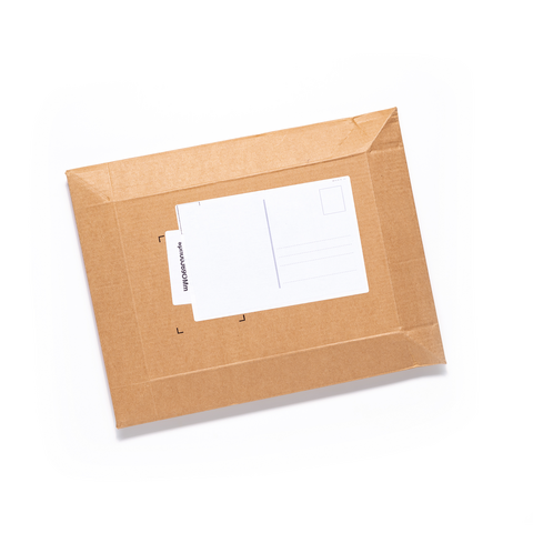 Brauner Umschlag mit einer leeren Postkarte auf der Vorderseite, bereit zum Versenden.