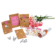 Geschenktüten mit Aufklebern, ein Blumenstrauß, Herzaufkleber, Geldscheine und eine Flasche Sekt.