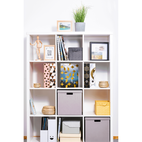 Regal mit offenen Fächern, gefüllt mit Bücher, Aufbewahrungskörben, Bilderrahmen und einer Pflanze. Ein Holzfigur steht auf dem Regal.