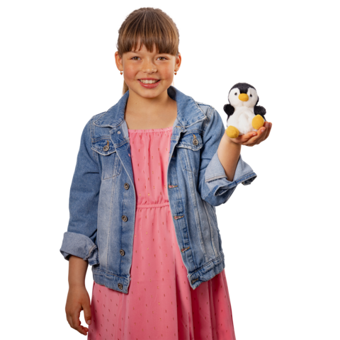 Ein Mädchen in einem rosa Kleid und einer Jeansjacke hält einen kleinen Plüsch-Pinguin in der Hand und lächelt."
(Note: The text is already in German and does not require translation. It is clear and fluent as is.)