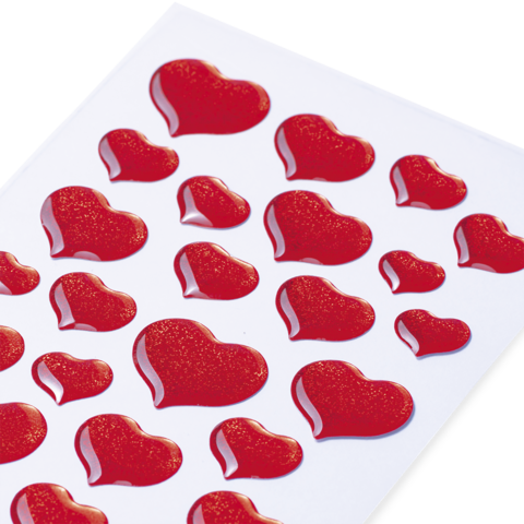 Rote Herzaufkleber auf einem weißen Blatt, in verschiedenen Größen und Formen angeordnet.