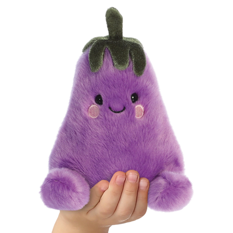 Lila, plüschige Aubergine mit einem lächelnden Gesicht und runden Wangen, wird von einer Hand gehalten."
(Note: The text is already in German and does not require translation. It is clear and fluent as it stands.)