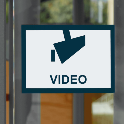 Schild mit einem Kamerasymbol und dem Wort "VIDEO" in großen Buchstaben.