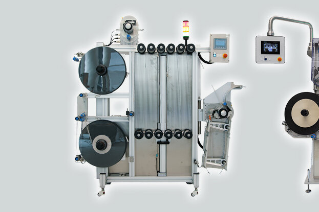 Maschine zur Materialverarbeitung mit mehreren Rollen und einem Bedienfeld, das verschiedene Funktionen steuert.