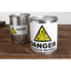 Metallbehälter mit Warnaufkleber "DANGER EXPLOSIVE MATERIAL" auf einem Holztisch. Ein weiterer Behälter im Hintergrund.
