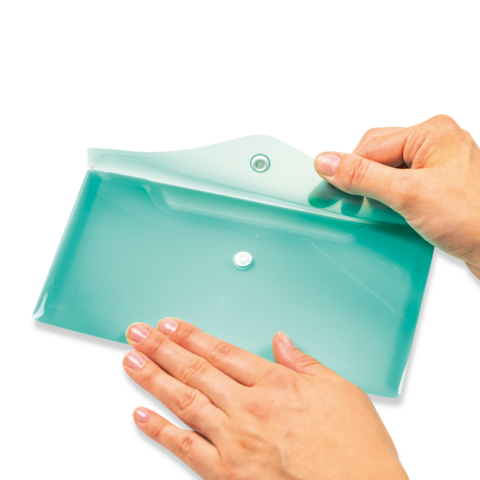 Eine Hand hält einen flachen, mintgrünen Behälter mit einem Deckel, während die andere Hand den Behälter berührt.