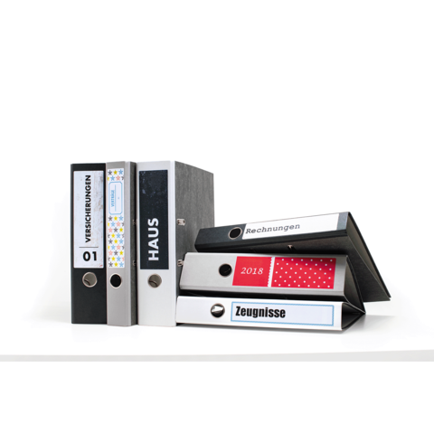 Eine Gruppe von Ordnern in verschiedenen Farben, beschriftet mit "Versicherungen", "Haus", "Rechnungen", "2018" und "Zeugnissen".